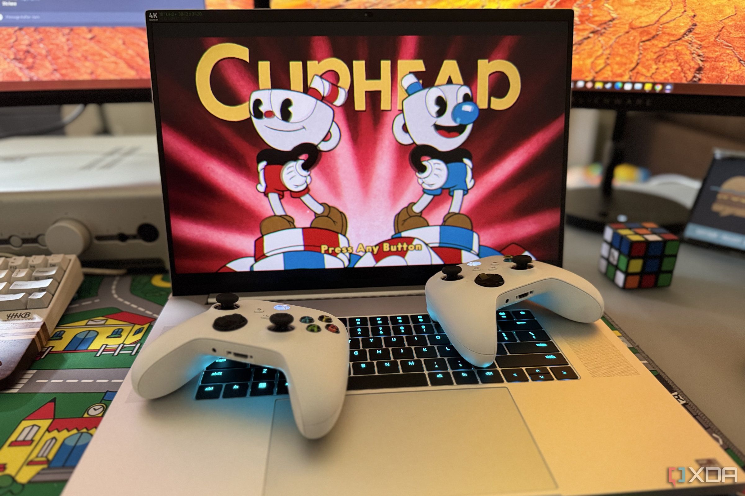 razer blade 18 gaming laptop playing cuphead with two xbox controllers on top of the keyboard