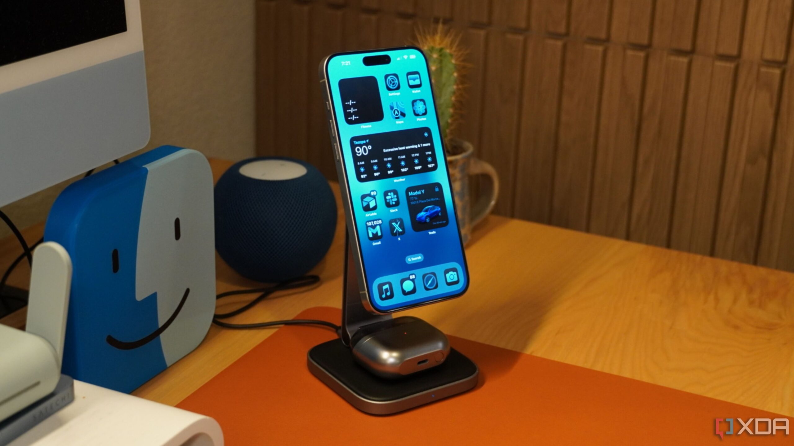 An iPhone and a pair of Galaxy Buds charging on a Satechi wireless charger.