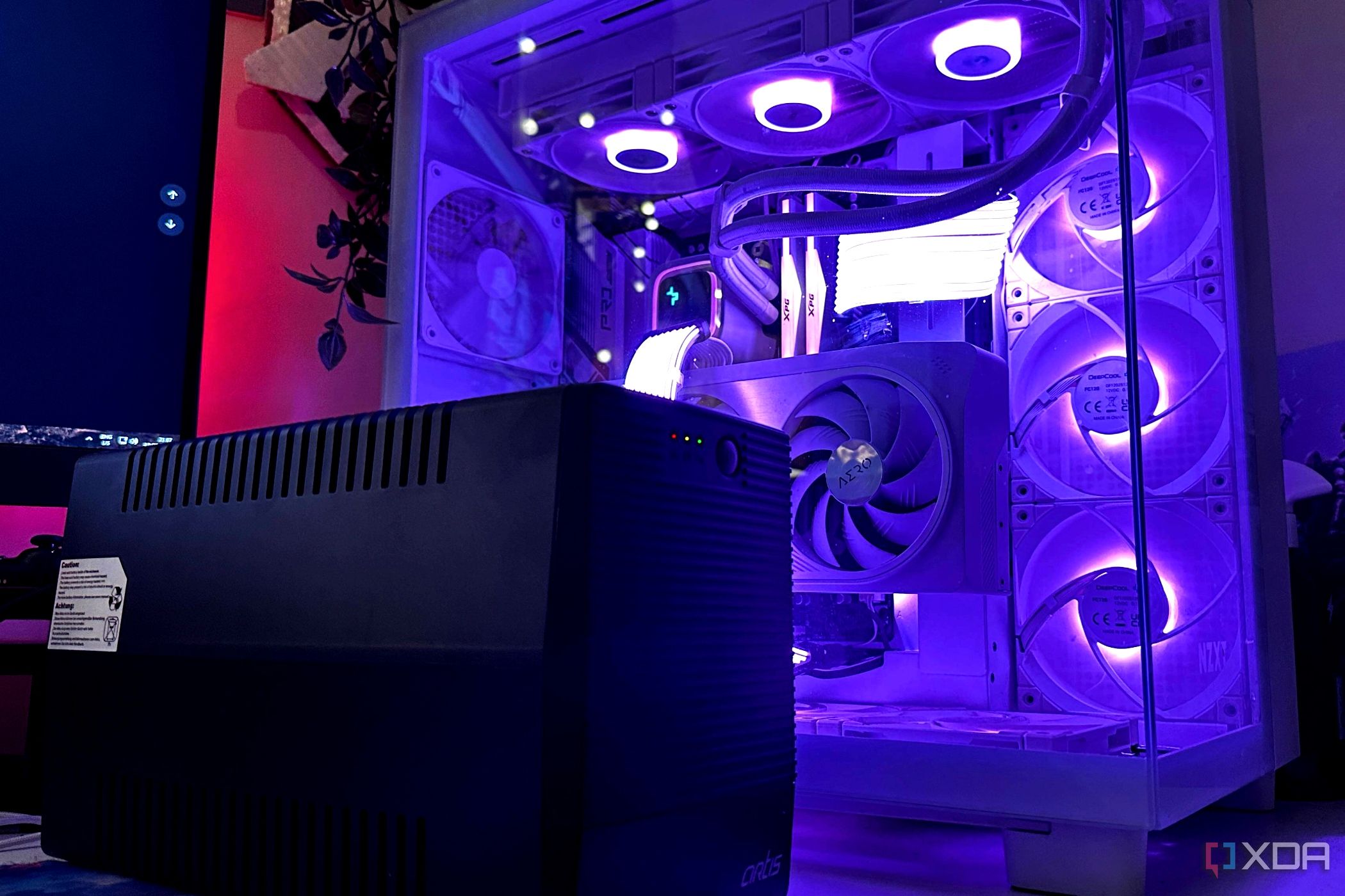 A black UPS inverter sitting next to a gaming PC cabinet
