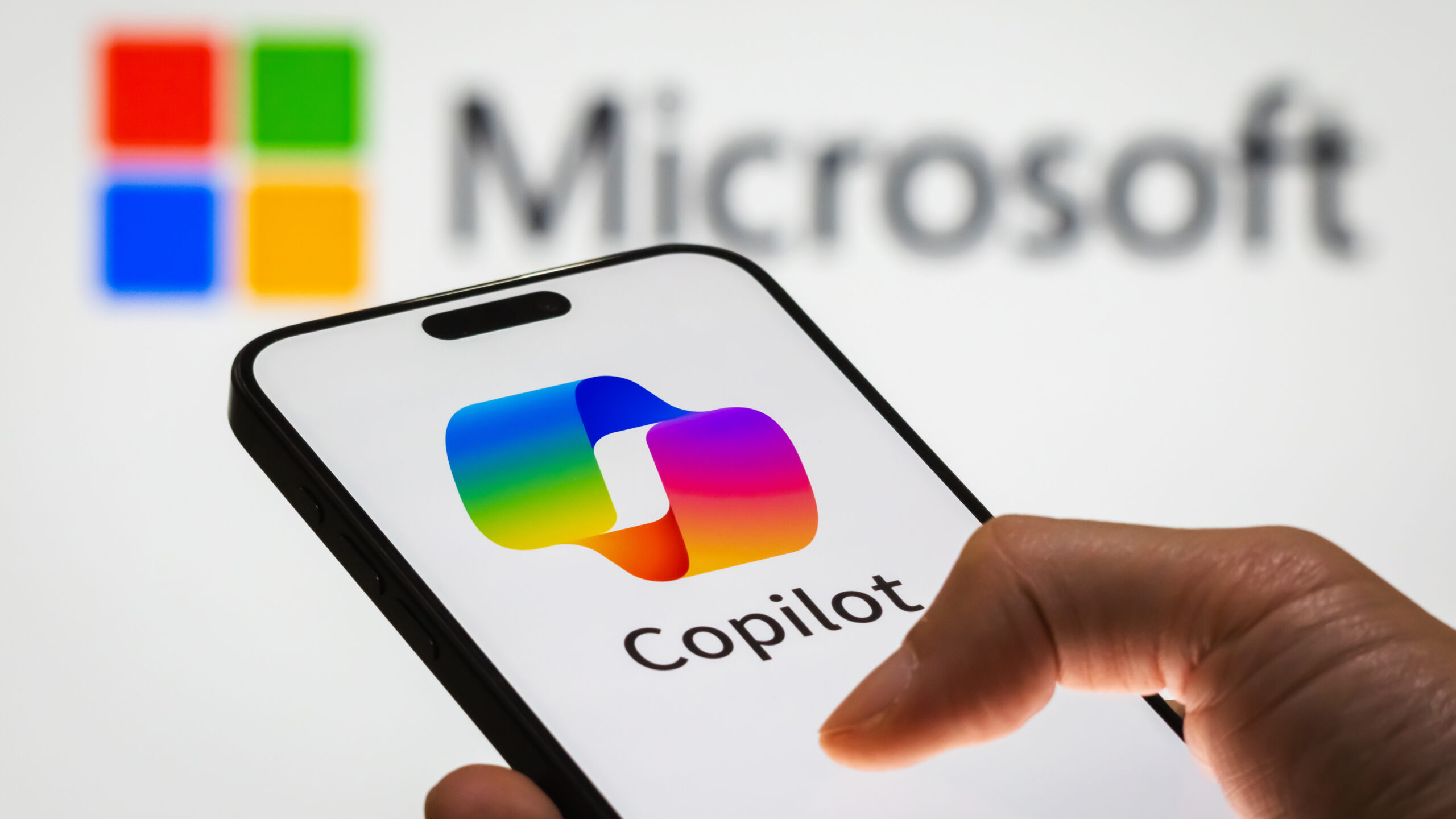 CHONGQING, CHINA - DECEMBER 29: In this photo illustration, a person holds a smartphone displaying the logo of Microsoft Copilot, an AI-powered productivity tool, with the Microsoft logo visible in the background, representing the integration of artificial intelligence into workplace solutions, on December 29, 2024 in Chongqing, China. Artificial Intelligence (AI) has become a cornerstone of China's strategic ambitions, with the government aiming to establish the country as a global leader in AI by 2030. (Photo illustration by Cheng Xin/Getty Images)